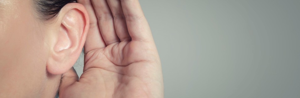 Detaljebillede af øre med hånd bagved